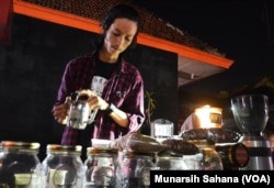 Jihan Fajari, coffee brewer sedang menyajikan kopi, coffee brweing dihadapan pengunjung Festivak Kopi Prawirotaman, Kamis malam (16/7/2017) (foto: VOA/Munarsih Sahana).