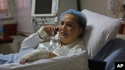 FILE - Afghan lawmaker Shukria Barakzai, injured in an attack Nov. 16, talks on her phone from her hospital bed in Kabul, Afghanistan, Nov. 23, 2014.