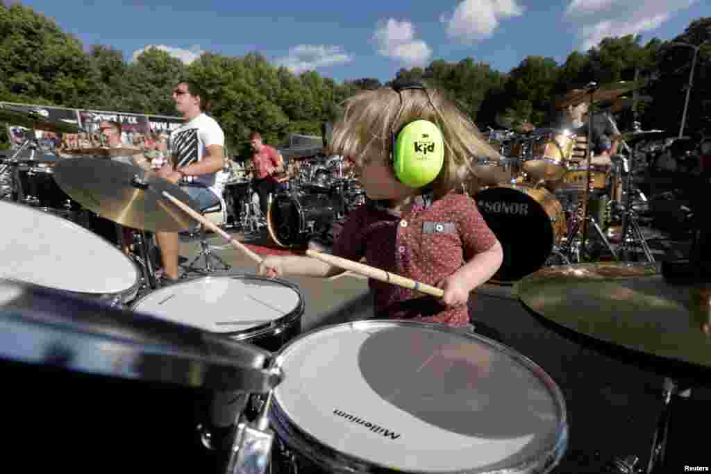 A boy plays together with more than 100 drummers performing during the Baltic Drummers' Summit in Riga, Latvia, July 10, 2016.