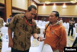 Former Indonesian militant Toni Togar, right, talks with Sarinah Jakarta bomb victim Denny Mahieu during a meeting between former militants and victims in Jakarta, Indonesia, Feb. 28, 2018.