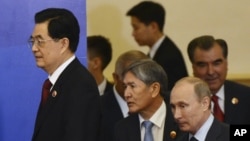 China's President Hu Jintao, left, is followed by Kyrgyzstan's President Almaz Atambayev, second left, Russia's President Vladimir Putin, second right, and Tajikistan's President Emomali Rahmonov as they walk to attend a signing ceremony at the Shanghai C