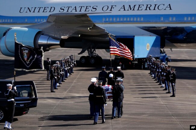 The flag-draped casket of former President George H.W. Bush is carried by a joint services military honor guard to Special Air Mission 41 at Ellington Field during a departure ceremony Monday, Dec. 3, 2018, in Houston, Texas.