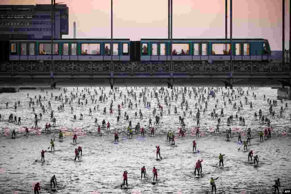 People take part in the 7th Edition of the Nautic SUP Paris Crossing stand up paddle competition on the river Seine, in Paris, France.