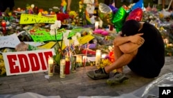 Jean Dasilva duduk di memorial untuk para korban pembantaian di Orlando, berduka cita atas kematian sahabatnya Javier Jorge-Reyes (14/6) di Orlando, Florida. (AP/David Goldman)