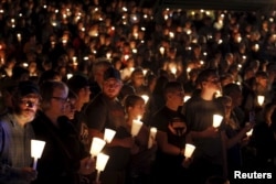 People take part in candlelight vigil following a mass shooting at Umpqua Community College in Roseburg, Oregon, Oct. 1, 2015.