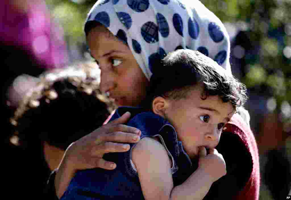 Seorang pengungsi Suriah menggendong adiknya di desa Ketermaya, sebelah tenggara Beirut, Lebanon. (AP/Hussein Malla)