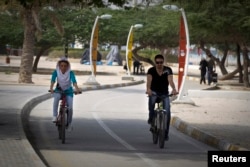 FILE - A couple rides bicycles on a bike path in Kish Island, approximately 1,250 kilometers (777 miles) south of Tehran, April 26, 2011.