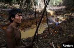 An Yanomami indian stands near an illegal gold mine during Brazil’s environmental agency operation against illegal gold mining on indigenous land, in the heart of the Amazon rainforest, in Roraima state, Brazil, April 17, 2016.