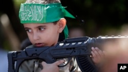 Dün Gazze'de Hamas'ın mitingine katılan oyuncak silahlı bir Filistinli çocuk