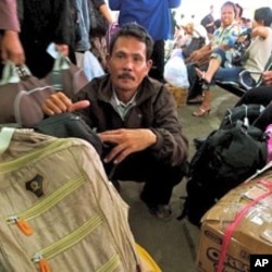 Wahyudi, a food vendor, will have to spend the night at the station with the boxes of clothes he plans to give to his children.