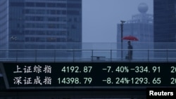 An electronic board, showing the benchmark Shanghai and Shenzhen stock indices, overlooks a pedestrian overpass at the Pudong financial district in Shanghai, China, June 26, 2015. 