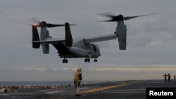 FILE - A U.S. Marines MV-22 Osprey Aircraft lands on the deck of the USS Bonhomme Richard amphibious assault ship off the coast of Sydney, Australia, June 29, 2017. 