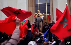 Demonstrators wave Moroccan flags during a protest in Paris, March 20, 2016.