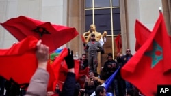 Demonstrators wave Moroccan flags during a protest in Paris, March 20, 2016. 