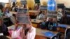 Second-graders in Alieu Samb primary school hold up chalk boards with French conjugations. Dakar, Senegal, Dec. 7 2017. (Photo: Sofia Christensen for VOA) 