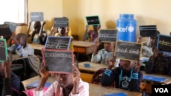 Second-graders in Alieu Samb primary school hold up chalk boards with French conjugations. Dakar, Senegal, Dec. 7 2017. (Photo: Sofia Christensen for VOA) 