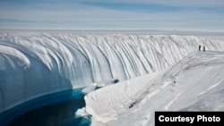 Surface melt water rushes along the surface of the Greenland Ice Sheet through a supra-glacial stream channel. [Image courtesy of Ian Joughin]