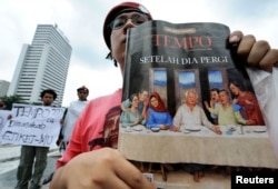 Seorang pengunjuk rasa menampilkan salinan berita mingguan, Tempo, saat demonstrasi menentang majalah tersebut di Jakarta pada 6 Februari 2008. (Foto: AFP)