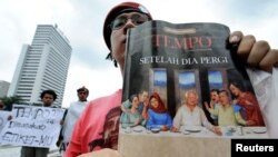 FILE - A protester displays a copy of the Indonesian news weekly, Tempo, during a demonstration against the magazine in Jakarta, Feb. 6, 2008. 