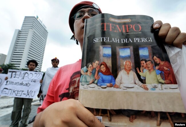 Seorang pengunjuk rasa menampilkan salinan berita mingguan, Tempo, saat demonstrasi menentang majalah tersebut di Jakarta pada 6 Februari 2008. (Foto: AFP)