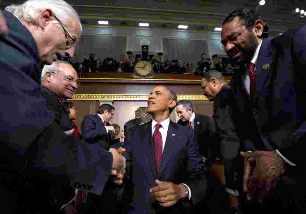 Presiden Barack Obama menjabat tangan para anggota Kongres sebelum menyampaikan pidatonya Selasa malam, 24 Januari di Gedung DPR AS, Washington (AP).