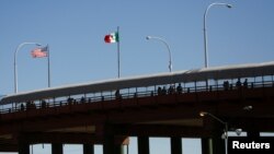 Migrantes centroamericanos, que fueron transportados en avión desde Brownsville a El Paso, Texas, EE. UU., y expulsados bajo el Título 42, caminan hacia México en el Puente Internacional Lerdo Stanton, visto desde Ciudad Juárez, México, el 25 de agosto de 2021.