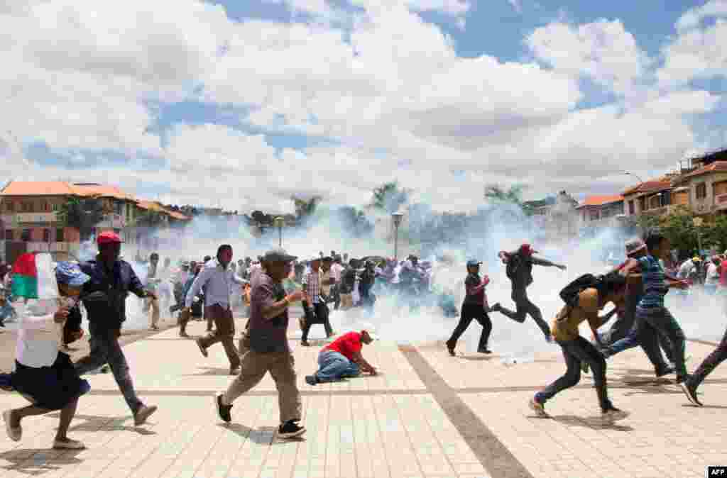 Supporters of Madagascar presidential candidate Marc Ravalomanana scramble as security forces fire teargas during a demonstration to protest election results in Antananarivo.