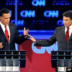 ອະດີດຜູ້ປົກຄອງລັດ Massachusetts ທ່ານ Mitt Romney (ຊ້າຍ) ຖົກຖຽງກັນກັບຜູ້ປົກຄອງລັດເທັກ ຊັສ ທ່ານ Rick Perry ໃນລະຫວ່າງການໂຕ້ວາທີ ຂອງພັກຣີພັບບລີກັນ ທີ່ເມືອງແທັມປາ ລັດຟລໍຣິດາ ເມື່ອວັນຈັນຜ່ານມາ, ທີ 12 ກັນຍາ 2011.
