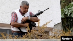 El general retirado Ángel Vivas monta guardia desde una terraza de su casa.