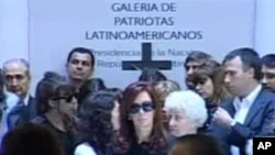 President Cristina Fernandez, center, stands next to the coffin of her husband, former President Nestor Kirchner, as mourners file past in Buenos Aires, Argentina, 28 Oct. 2010
