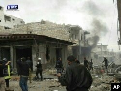 In this photo provided Jan. 3, 2018, by the Syrian anti-government activist group, Edlib Media Center, EMC, which has been authenticated based on its contents and other AP reporting, shows members of the Syrian civil defense known as the White Helmets, gathering at a street which was attacked by Russian airstrikes, in Ma'arrat An Nu'man town, southern Idlib province, Syria.