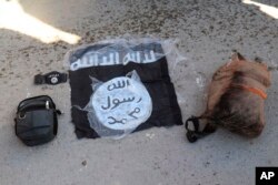 Bendera dan tas para pejuang ISIS yang ditangkap oleh Pasukan Demokratik Suriah pimpinan Kurdi pasca serangan di Penjara Gweiran, Hassakeh, timurlaut Suriah, 21 Januari 2022. (Pasukan Demokratik Suriah pimpinan Kurdi via AP)