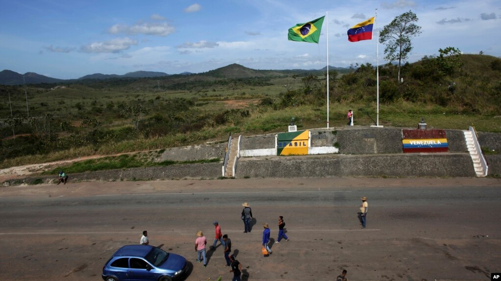 Archivo. En esta foto del 10 de marzo de 2018 se ve gente en la frontera entre Venezuela y Brasil cerca de la ciudad brasileña de Pacaraima, en el Estado Roraima.