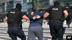 FILE - Kosovo police detain a terror suspect in the capital Pristina.