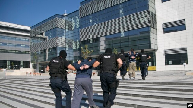 La policía de Kósovo lleva a la corte en Pristina a albaneses no identificados, sospechosos de participar en un complot terrorista. Dic. 1 de 2015.