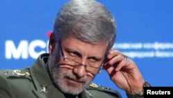 FILE - Iranian Defense Minister Amir Hatami adjusts a headphone during the annual Moscow Conference on International Security in Moscow, April 4, 2018.