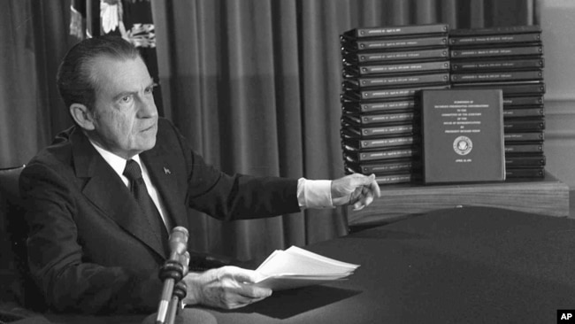 FILE - President Richard M. Nixon is shown pointing to the transcripts of the White House tapes in this Apr. 29, 1974 photo, after he announced during a nationally-televised speech that he would turn over the transcripts to House impeachment investigators.
