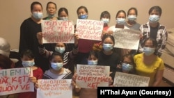 Những người phụ nữ Việt Nam cầm bảng kêu cứu trong một cơ sở tạm trú dành cho lao động nước ngoài gặp khốn khó, ở Riyadh, Ả-rập Saudi. Nhiều người trong số này nói họ bị chủ lao động hành hạ.