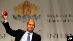 Bulgarian Socialists Party candidate Rumen Radev gestures with an apple during a press conference after presidential elections in Sofia, Bulgaria, Nov. 13, 2016. Radev hopes to lift EU sanctions against Russia.