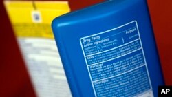 FILE - Sunscreen ingredients, including oxybenzone, are shown, in San Jose, Calif., May 2, 2018. In an attempt to protect the coral reefs, the Pacific nation of Palau will soon ban many types of sunscreen. The law defines reef-toxic sunscreen as containing any one of 10 chemicals, including oxybenzone, and states that other chemicals may also be banned.
