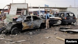 Residents gather at the site of a car bomb attack in al-Habibya district in Baghdad, April 16, 2013. 