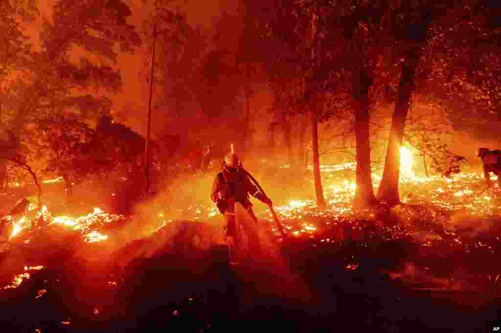 A firefighter battles the Creek Fire as it threatens homes in the Cascadel Woods neighborhood of Madera County, California.