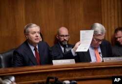 Sen. Lindsey Graham, chairman of the Senate Judiciary subcommittee on Crime and Terrorism, joined by Sen. Sheldon Whitehouse, displays a letter to FBI Director James Comey saying Congress needs to get to the bottom of charges by President Trump that his o