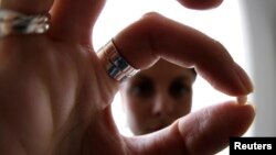 An illustrative photo shows a woman holding a birth control pill.