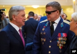 Vladimir Vshivtsev, a veteran of the Soviet war in Afghanistan, right, and Gen. Col. Boris Gromov, former Commander of the 40th Army in Afghanistan, greet each other during a meeting at the upper chamber of Russian parliament in Moscow, Russia, Feb. 14, 2019.