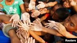 Children scramble to get a ticket for free meals offered by a feeding programme in a squatter area, in Baseco, Tondo, Metro Manila, Philippines, May 2012.