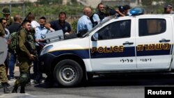 Israeli forces gather at the scene of a Palestinian car-ramming attack at the entrance of Beit Einun village, near the West Bank city of Hebron, July 18, 2017. 