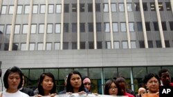 FILE - Supporters of immigration reform stand in front of U.S. Citizenship and Immigration Services in New York, June 25, 2012. 