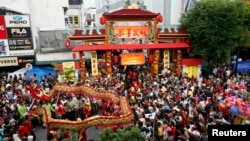 FILE - Residents watch a dragon dance ahead of the Cap Go Meh festival on Monday, which marks the end of Chinese New Year celebrations, on Malioboro street in Yogyakarta, Central Java, Indonesia, Feb. 7, 2009. 