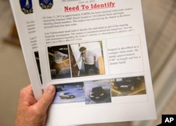 Charleston Emergency Management Director Mark Wilbert holds a flier showing surveillance footage of a suspect wanted in connection with the shooting Wednesday at Emanuel AME Church in Charleston, S.C., June 18, 2015.